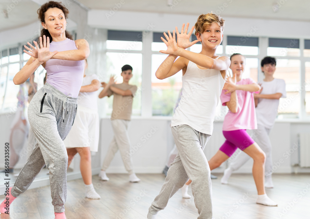Naklejka premium Group of teenagers learn to dance hip-hop and other modern dances in a spacious dance studio