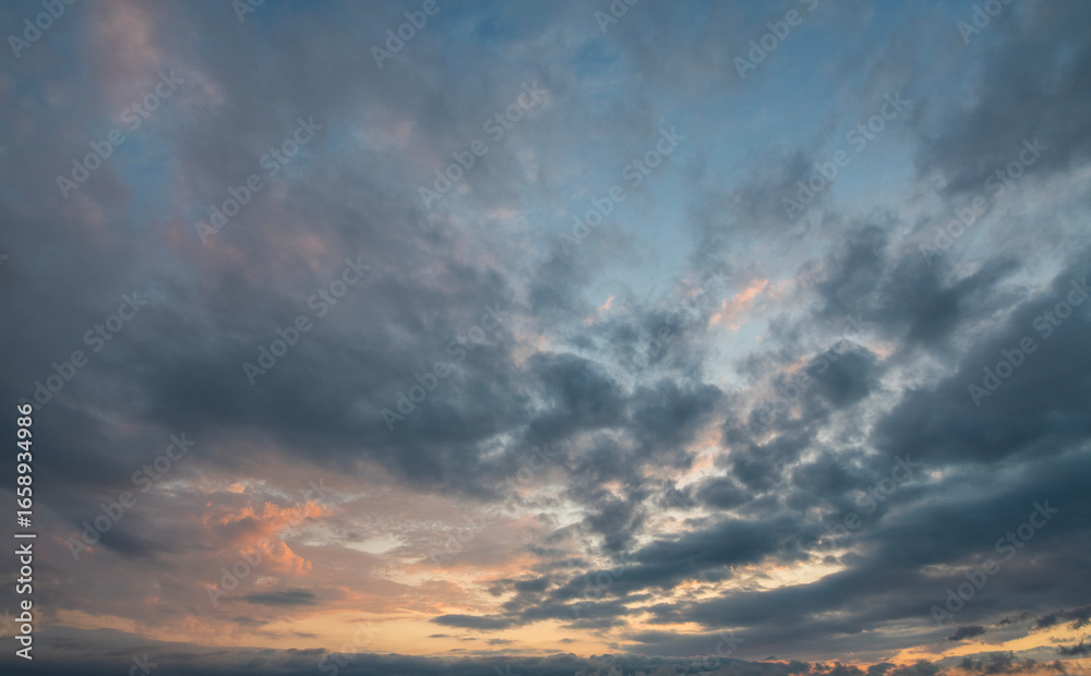 Fototapeta premium Evening sunset sky background with bright dramatic clouds.