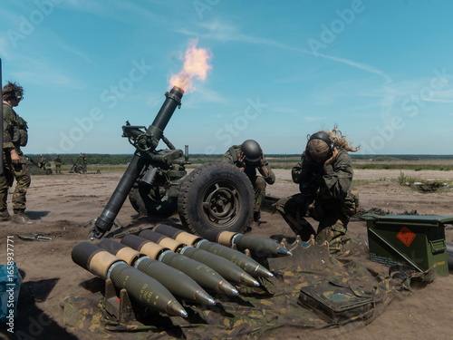 Canvas Print Military mortar firing with soldiers operating equipment and artillery shells vi