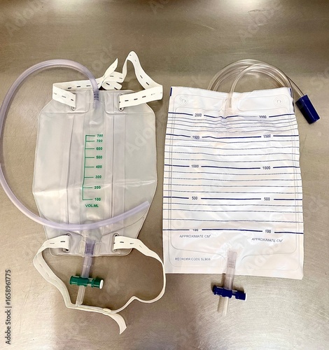Two different types of medical urine drainage bags on a stainless steel surface