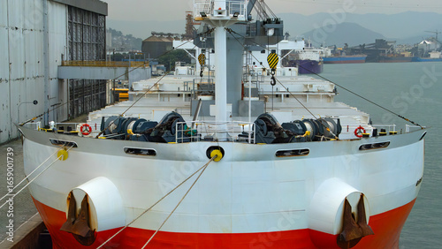 Fotografie Large cargo ship is moored in a port, with a close-up view of its bow, anchors,