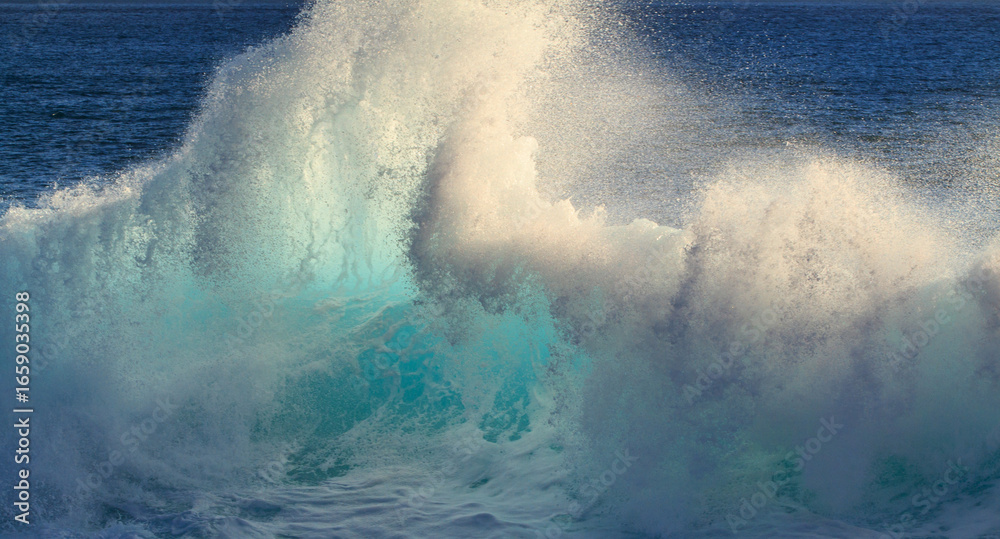 Obraz premium Giant ocean wave illuminated by sunset light. Enormous ocean wave rising high with golden sunset tones, showcasing the dramatic strength, power, and beauty of nature at sea.