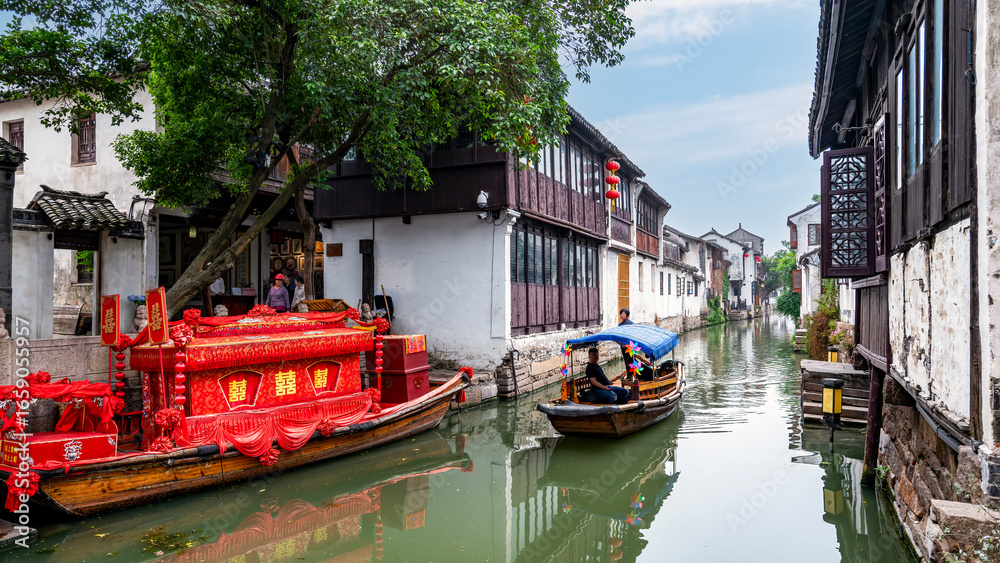 Obraz premium Traditional Chinese boats gliding through canal in ancient town