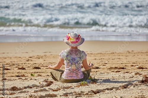 A hat, a woman and the ocean become one with yoga