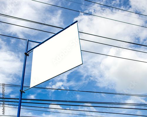 Blank advertisement board on blue sky with messy power cords 
