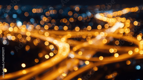 City interchange at night with glowing lights and abstract bokeh effect.
