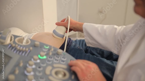 Close-up of a doctor doing an ultrasound on a pregnant woman. Screening of the third trimester 
