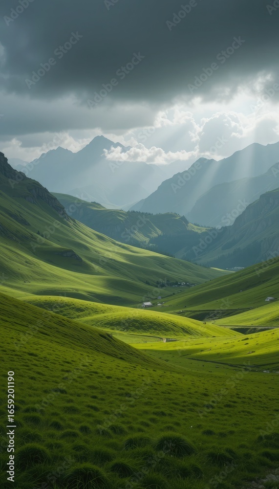 Obraz premium Sunbeams illuminate lush green mountain valley with scattered houses