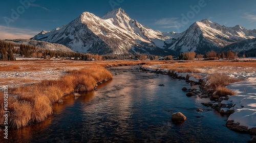 Late afternoon landscape showing shadows stretching across the fields of Silver Creek with a dramatic backdrop of sunlit Idaho mountains   
