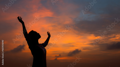 Silhouette of prayer woman worship God in the morning with sunrise sky background Person hands open palm up worship God helping repent catholic easter lent mind pray Christian religion 