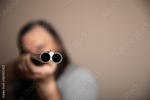 Photography A man is holding a shotgun and looking at the camera