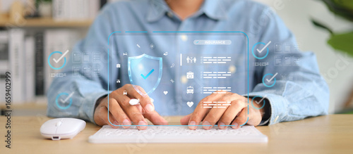Photos Businessman typing on keyboard with futuristic insurance and protection interface, shield security icon, checklist, and digital healthcare symbols