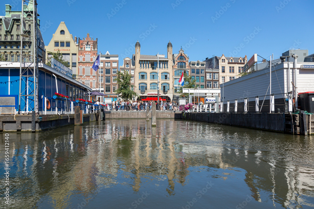 Fototapeta premium Amsterdam, Netherlands - July 02, 2018: View of the mooring of pleasure boats on Damrak Street in Amsterdam