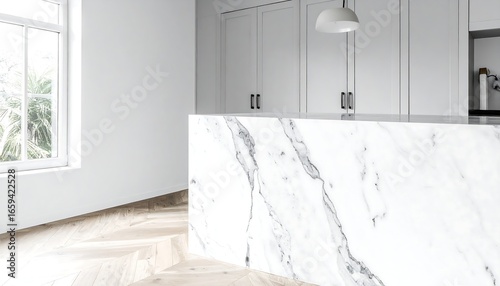 Modern kitchen island with white marble countertop and white cabinetry, herringbone wood floor