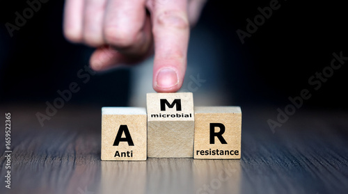 Wooden cubes showing the acronym AMR for antimicrobial resistance, symbolizing healthcare, microbiology, drug resistance, and global health awareness in a medical context.