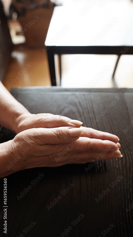 Obraz premium Elderly woman’s wrinkled hands clasped together, senior healthcare concern and aging health issues