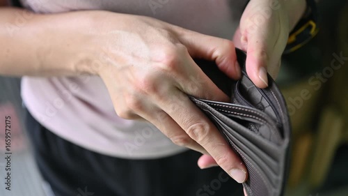 Footage of woman holding an empty wallet. Having financial problems means being unable to pay debts over the short or long term.