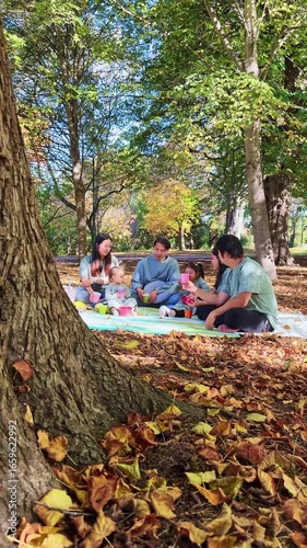 Asian family enjoying a picnic during autumn in New Zealand