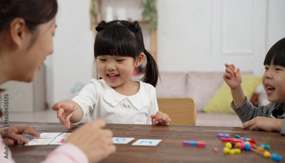 Fototapeta premium A toddler pointing at alphabet cards while a caregiver helps pronounce the letters