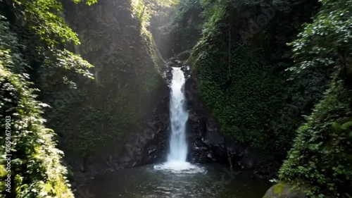 Waterfall cascading down a rocky gorge in a lush rainforest.