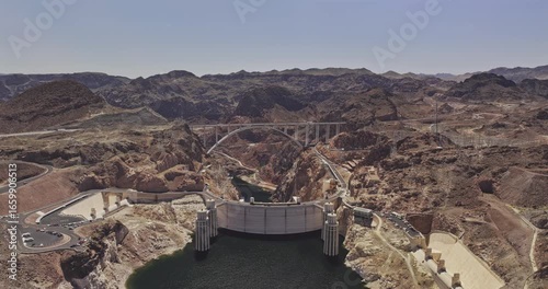 Hoover Dam Nevada Aerial v22 reverse flyover capturing a concrete arch-gravity dam and bypass bridge in Black Canyon, surrounded by rugged desert landscape - Shot with Mavic 3 Pro Cine - Apr 16th 2024