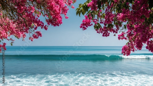 Serene Coastal View with Pink Flowers Framing Tranquil Ocean Waves and Clear Blue Sky