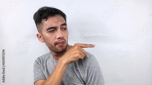 Man pointing to the side with a confused expression.
