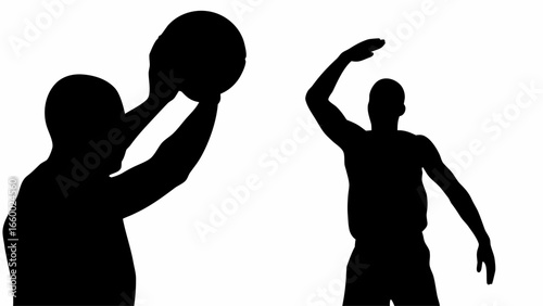 Silhouette of basketball players in action with one holding the ball and the other defending closely