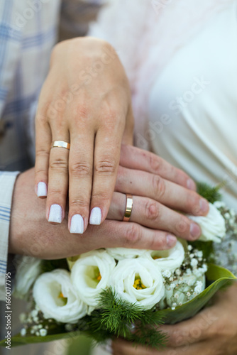 Hands of newlyweds with wedding rings, close-up.