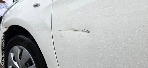 Photos The left front door of the car has a deep scratch from an accident while it was raining