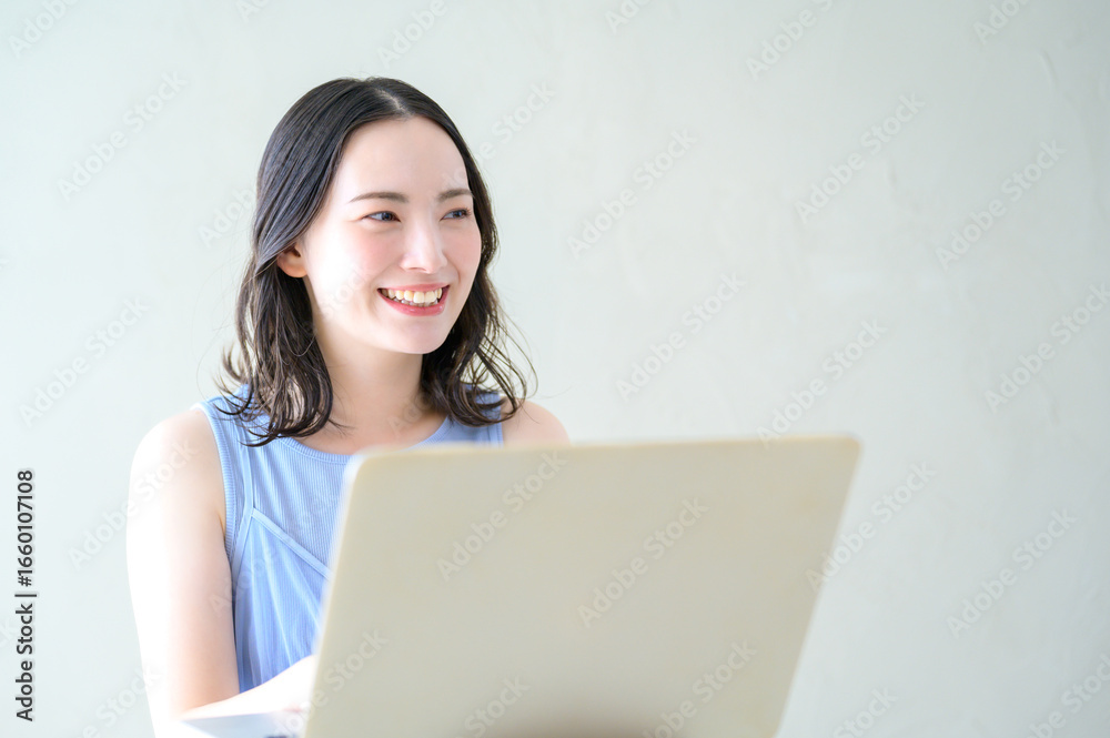 Fototapeta premium ノースリーブでパソコンを操作する日本人女性