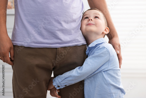 Принти на полотні Little boy clinging to his father indoors. Separation anxiety