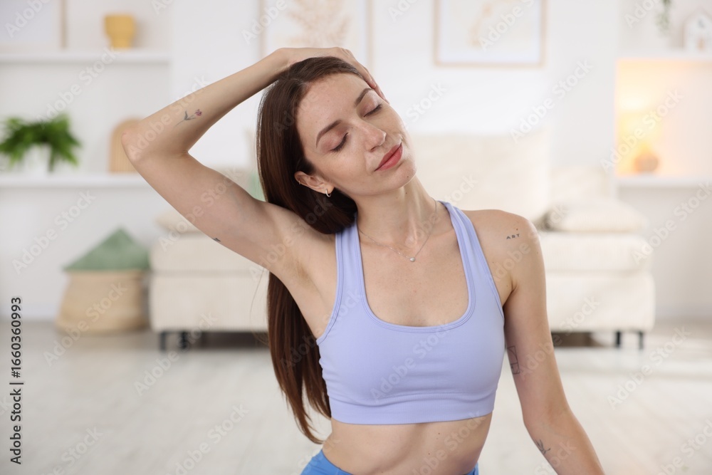 Young woman in sportswear stretching at home Young woman in sportswear stretching at home
