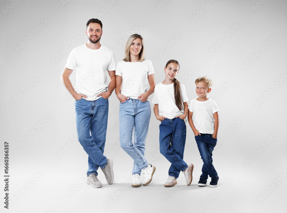 Obraz premium Happy parents and their children posing on grey background. Family