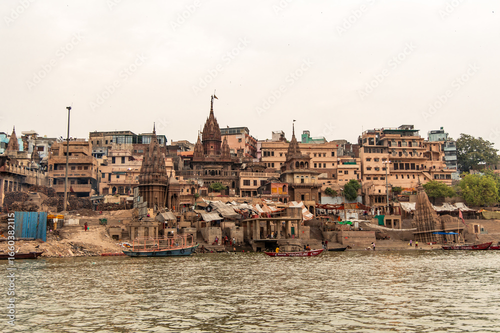 Varanasi cityscape rising from Ganges river with traditional buildings and temples Varanasi cityscape rising from Ganges river with traditional buildings and temples