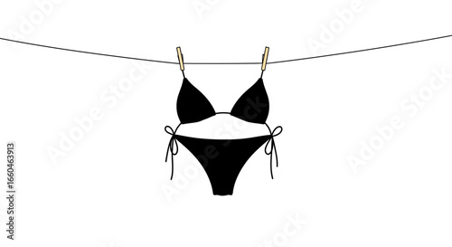 Minimalist black bikini hanging on clothesline with clothespins