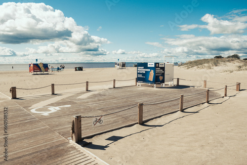 Fototapeta Naklejka Na Ścianę i Meble -  Wooden boardwalk and beach changing cabin for people with disabilities on a sandy beach in Parnu, Estonia, Europe