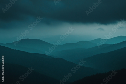 Moody mountain range landscape with dramatic, atmospheric blue tones