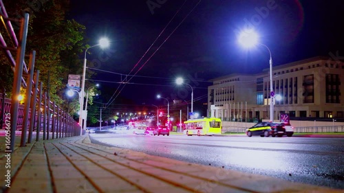 night city street, low shooting point, approaching cars and buses with headlights on, street lamps, multi-colored glare and reflections of light