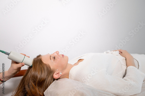 Tableau sur toile Non-invasive facial lifting: woman undergoing microcurrent therapy for firmer sk