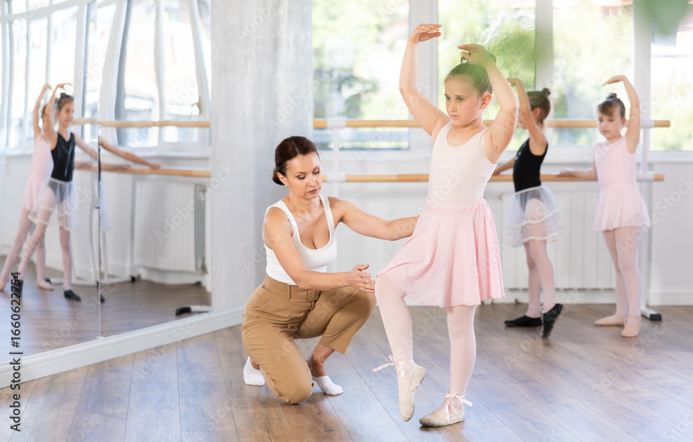 Fototapeta premium During ballet training, teacher corrects student, teaches her to keep posture correctly and beautifully, perform dance elements.