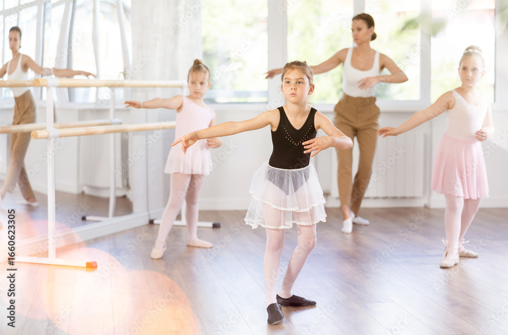 Naklejka premium Ballet lesson for children - choreographer teaches girls ballet steps
