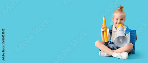 Cute little schoolgirl with big pencil and megaphone on blue background