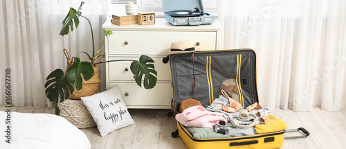 Unpacked suitcase with clot...