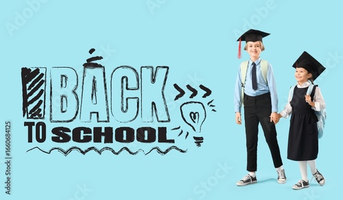 Little children in graduation hats holding hands on light blue background. Ba...