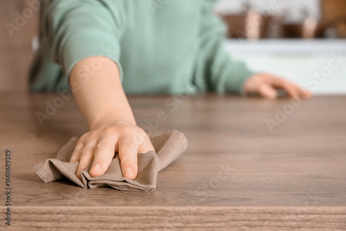 Woman cleaning wooden table...
