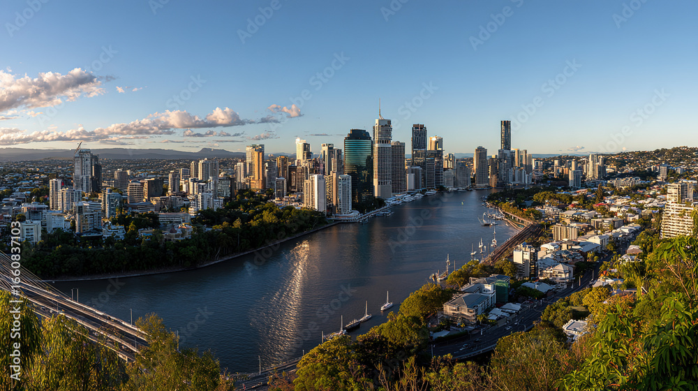 Naklejka premium Sunrise Panoramic City View with Shimmering River and Lush Greenery