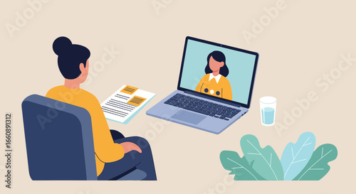 Woman sits in a chair, facing a laptop for a video call with another woman, with documents and a glass of water nearby.