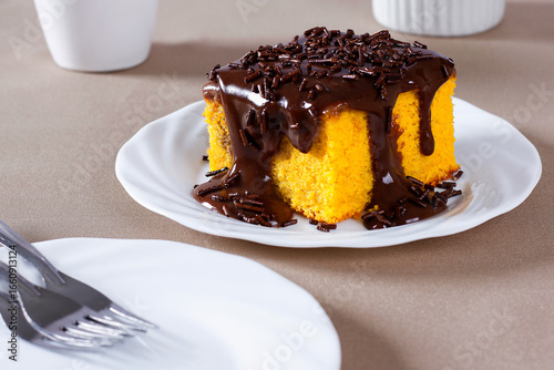 Slice of carrot cake with chocolate frosting on a ceramic plate. homemade Brazilian dessert