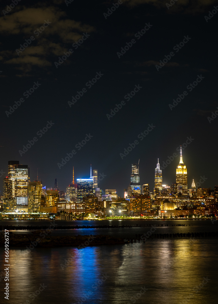 Fototapeta premium New York City at night. NYC cityscape with skyscrapers. Panoramic of New York City skyline on dusk. Manhattan skyline. New York and Hudson River. Downtown NYC. New York skyscrapers on sunset.